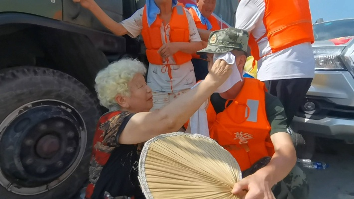 执勤军人遭高温考验，热心阿姨递送凉意不停扇风助解暑热